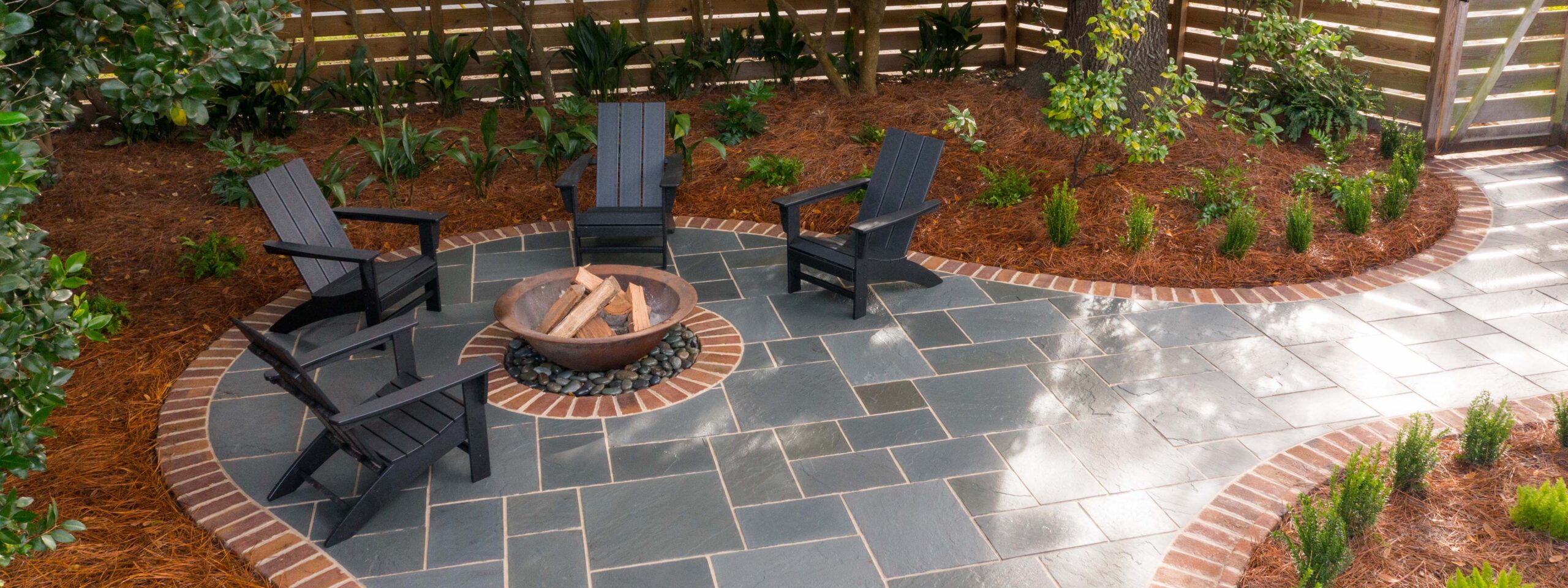 A Dreamer and Her Craftsman bluestone patio install with brick edging and fire pit.